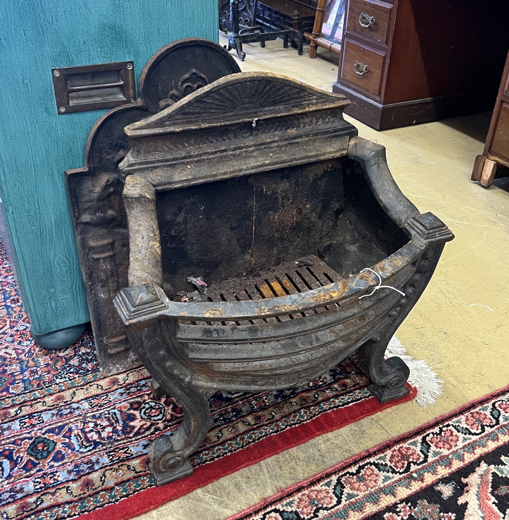 A 19th century cast iron bow front fire grate, width 56cm, depth 28cm, height 61cm together with a cast iron fire back